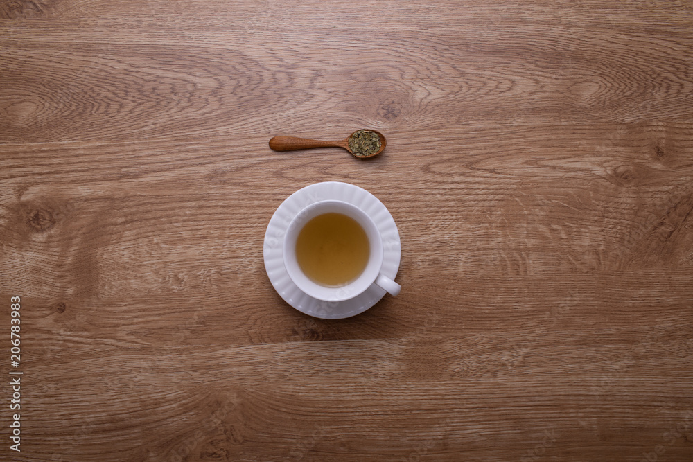 Obraz premium A glass of hot tea put on brown wood texture table.