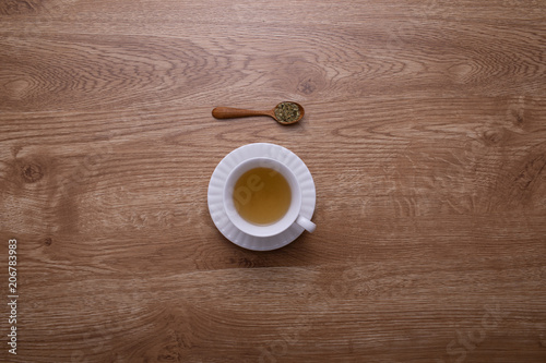 A glass of hot tea put on brown wood texture table.