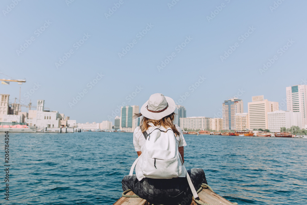 Young beautiful woman sitting at boat and looking at sea and the city DUbai Young beautiful woman sitting at boat and looking at sea and the city DUbai