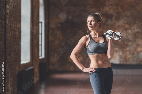Young sporty woman with a dumbbell in training