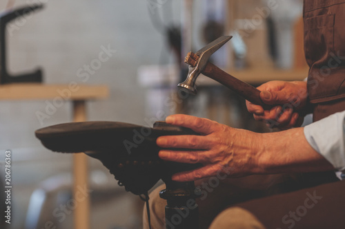 Bild auf Leinwand An elderly shoemaker at work close-up