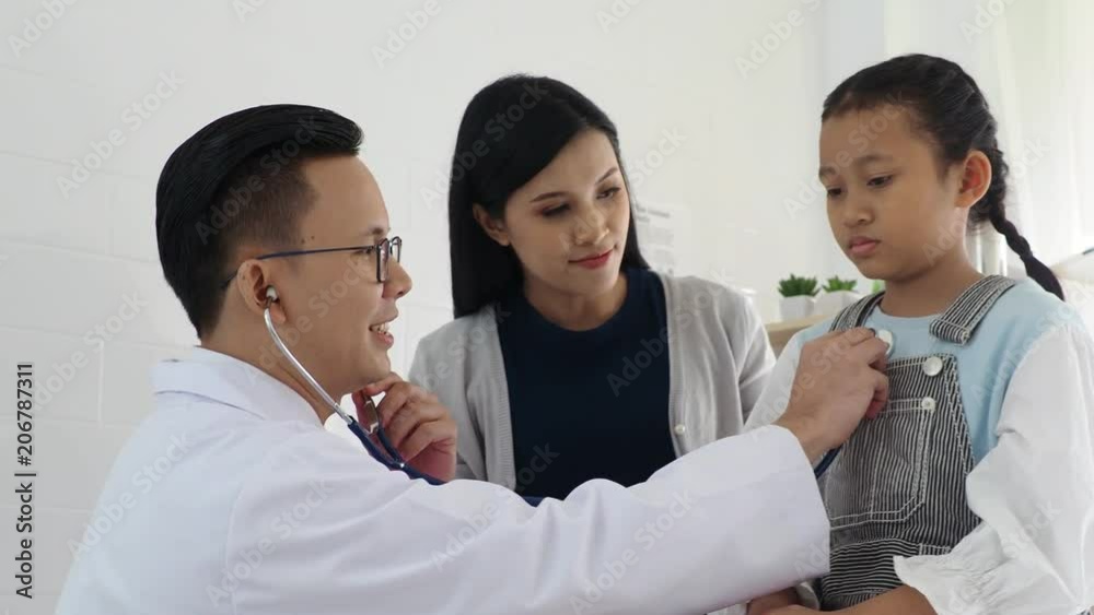 Asian medical doctor examining a little girl by stethoscope in clinic Asian medical doctor examining a little girl by stethoscope in clinic