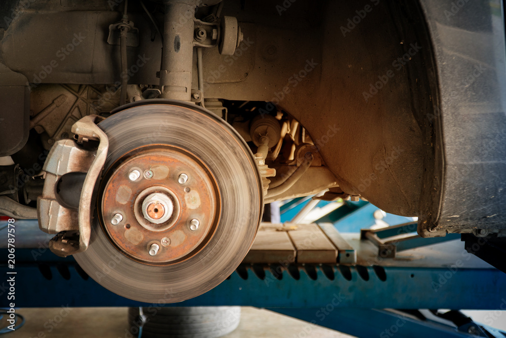 Rusted disc brake and caliper on car with space for text input.
