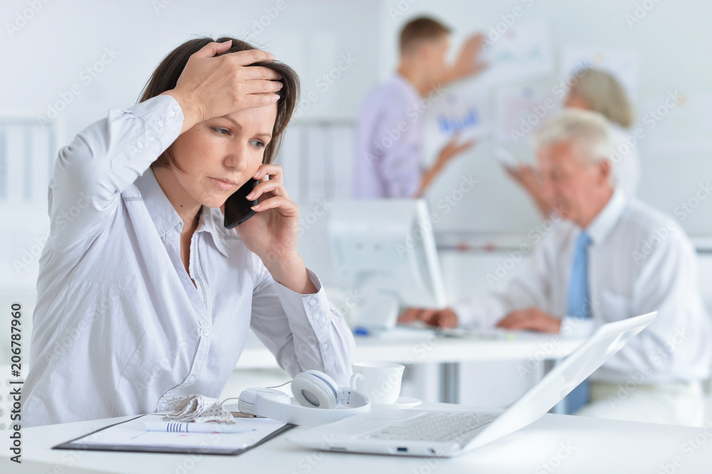 Fototapeta premium Young woman with headache working