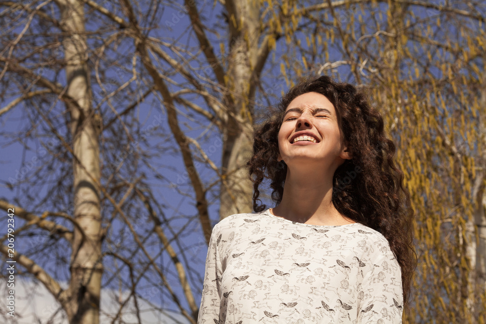 Woman enjoying the spring sun. Woman on blossoming of birch background. Spring concept. Woman enjoying the spring sun. Woman on blossoming of birch background. Spring concept.