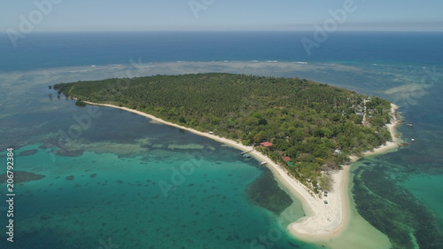 Tropical island with white sandy beach. Aerial view: Magalawa island with colorful reef. Seascape, ocean and beautiful beach paradise. Philippines,Luzon. Travel concept.