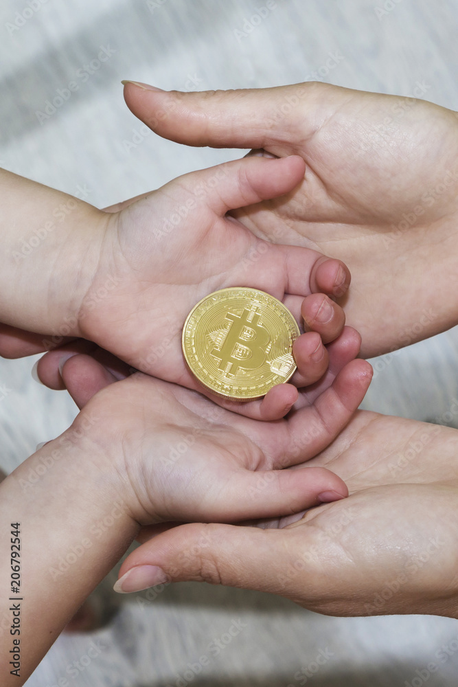 Bitcoin concept. Children share bitcoin. Child hand and bitcoin. Bitcoin concept. Children share bitcoin. Child hand and bitcoin.