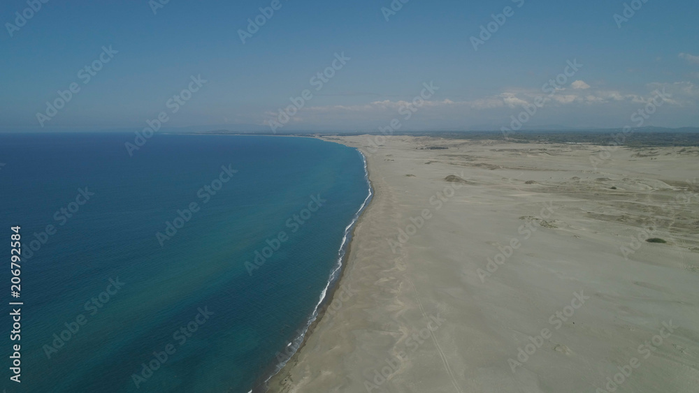 Aerial view of beautiful lonely beach and Paoay sand dune. Philippines, Luzon. Sand dunes near to the sea with sky. Ilocos Norte.