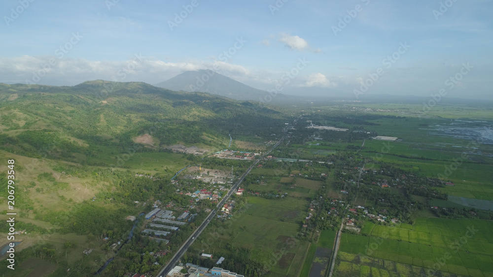 Aerial view of town in a mountain valley at the foot of the mountain Iriga. Luzon, Philippines. Mountainous tropical landscape.