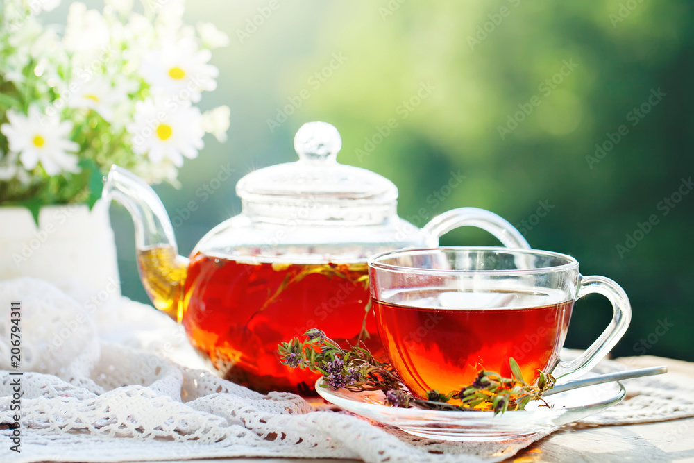 Cup with hot tea with mint and a thyme on a wooden table in a summer garden. Selective focus, Cup with hot tea with mint and a thyme on a wooden table in a summer garden. Selective focus,