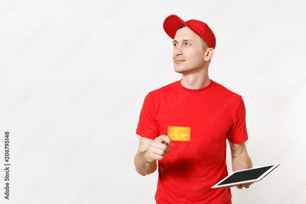 Delivery man in red uniform isolated on white background. Male in cap, t-shirt working as courier or dealer, holding tablet pc computer with blank empty screen, credit card. Copy space advertisement. Delivery man in red uniform isolated on white background. Male in cap, t-shirt working as courier or dealer, holding tablet pc computer with blank empty screen, credit card. Copy space advertisement.