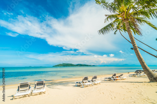 Fototapeta Naklejka Na Ścianę i Meble -  Beautiful tropical beach and sea with coconut palm tree and chair in paradise island