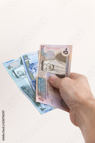 Male hand holding Jordanian dinars