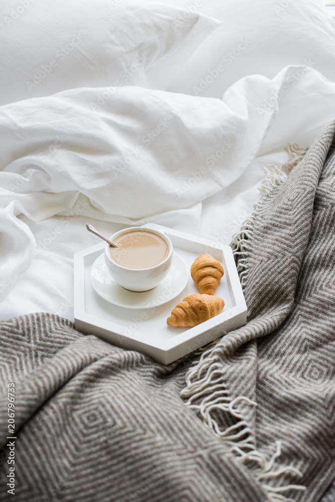 Cozy breakfast in bed, cup of coffee and croissants on white and Cozy breakfast in bed, cup of coffee and croissants on white and