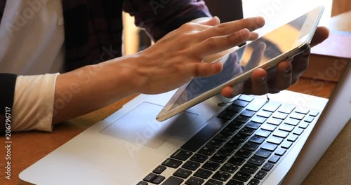 Hands of Asian young man using tablet and laptop computer