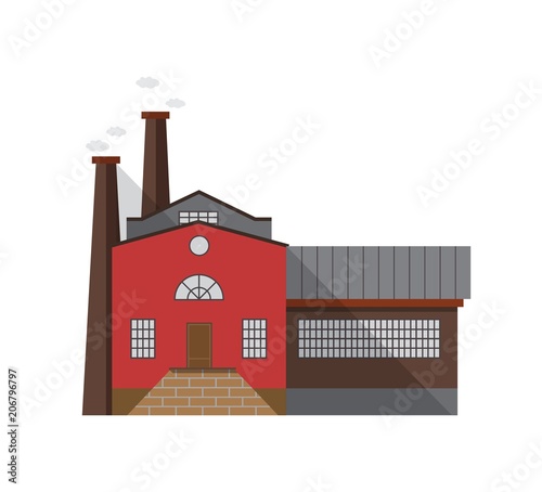Old-fashioned manufacturing building with entrance door and pipes emitting ga...