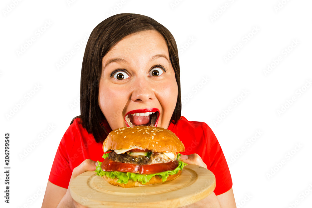 Young fat woman holds hamburger, smiles with opened mouth isolated on white background.
