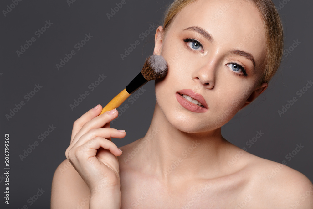 Obraz premium Beauty portrait of a smiling beautiful half naked woman posing with make-up brushes