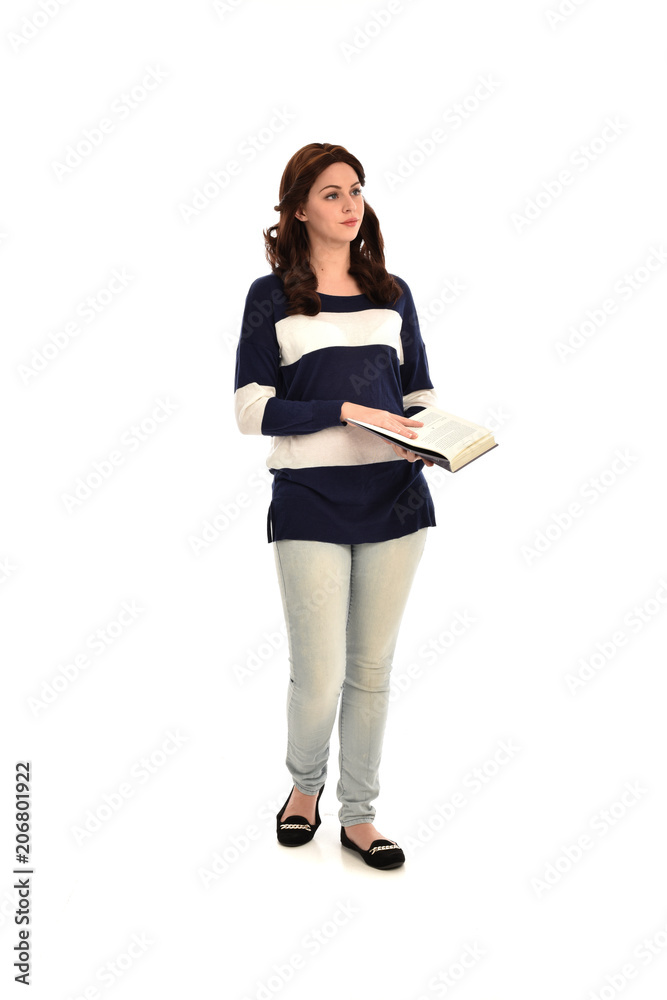 full length portrait of girl wearing striped blue and white jumper and jeans and holding a book. standing pose on white studio background full length portrait of girl wearing striped blue and white jumper and jeans and holding a book. standing pose on white studio background