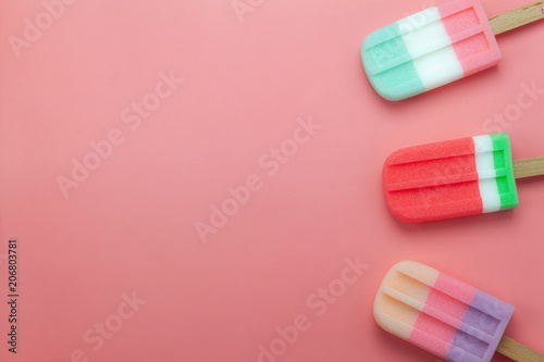 Table top view aerial image of food for summer holiday background concept.Flat lay arrangement variety ice cream pop stick on modern rustic pink paper wallpaper at office desk.Pastel tone design.