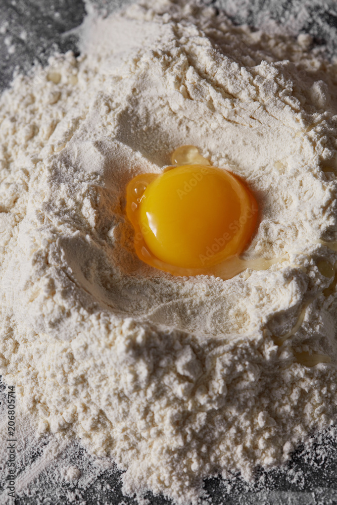 Raw egg and flour on the kitchen table, staged cooking dough Raw egg and flour on the kitchen table, staged cooking dough