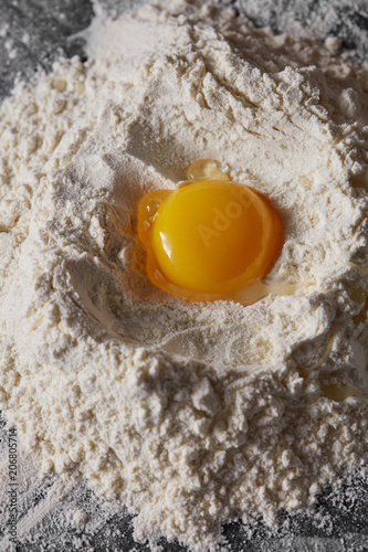 Raw egg and flour on the kitchen table, staged cooking dough