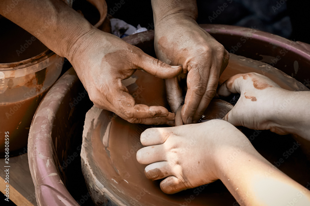 Pottery training. The hands of the pupil and master over the potter.