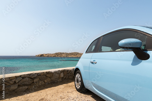 Light blue rental car parked next to the sea in Mykonos island, Greece © oleksii.leonov