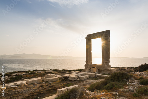 фотография View over ruins of ancient marble doorway monument Portara at sunset in Naxos, Greece