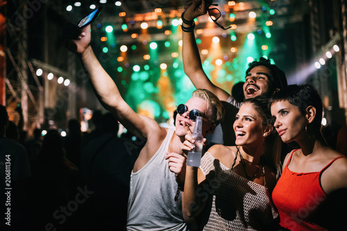 Happy friends having fun at music festival