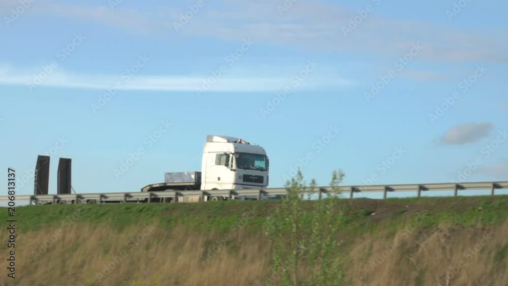 Cargo truck travel on inter city highways. International cargo transportation. Truck car drives through the bridge. Cargo truck travel on inter city highways. International cargo transportation. Truck car drives through the bridge.