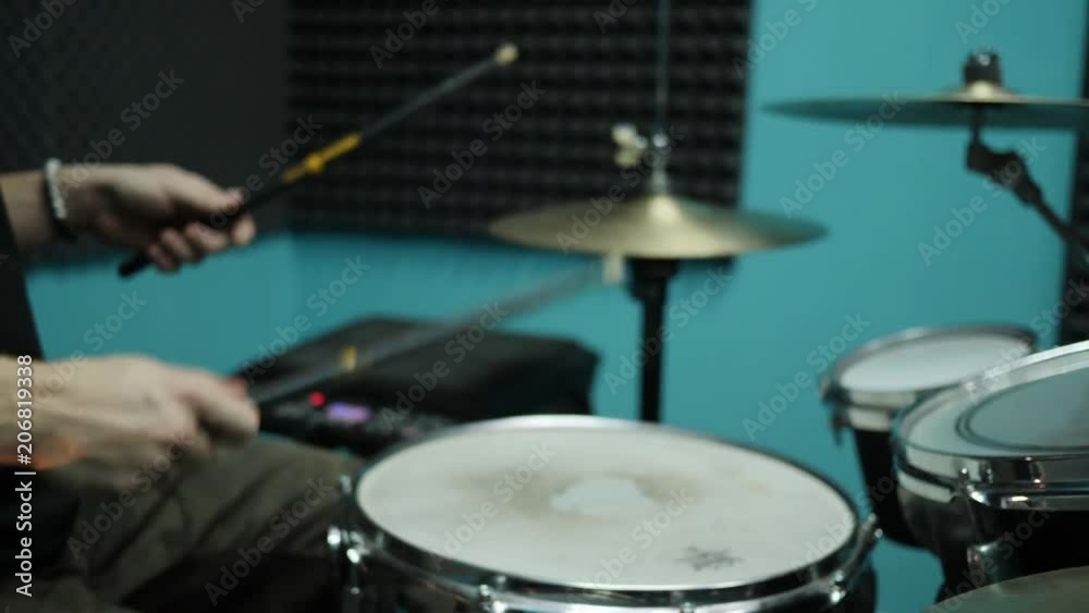 Out of focus shot of drummer playing on a drum kit. Musician rehearse in a studio Out of focus shot of drummer playing on a drum kit. Musician rehearse in a studio