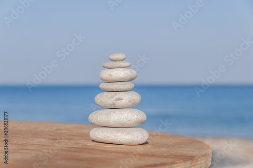 Several Zen stones stress balanced on blurred sea and beach