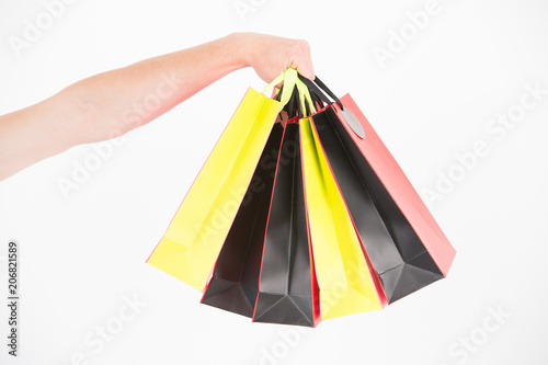 Male hand holds five shopping bags. Shopping concept. Hand holds bunch of colorful shopping bags. Shopping on black friday. Client bought lot items with discount