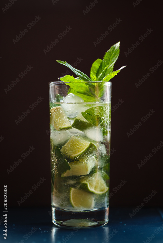 Mojito in a glass and lime, ice and green mint. Mojito in a glass and lime, ice and green mint.