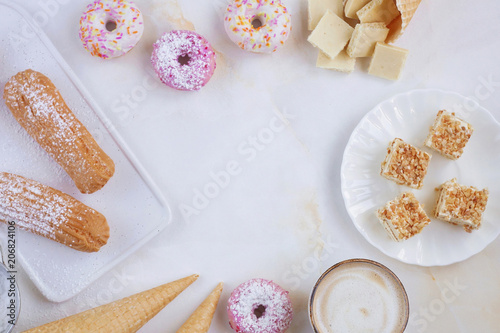 Eclairs and donuts with coffee on a marble background, Light background, Confectionery in a blogger style, Copy space