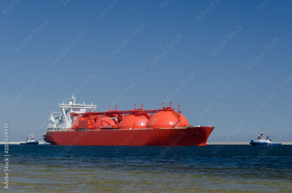 LNG TANKER - The red ship enters port with assurance of tugs