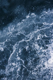 Surface of the sea with waves,  splash,  foam and bubbles at high tide and surf, blue abstract background