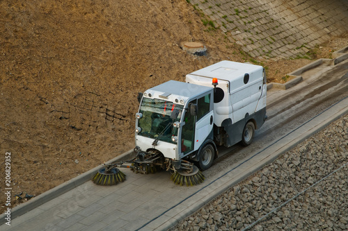 Street cleaning sweeper truck on the road. Top view.