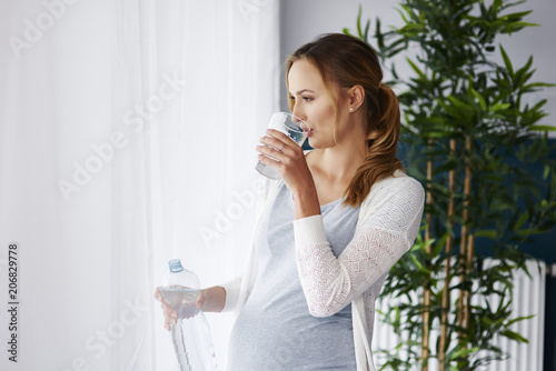 Young pregnant woman drinking water