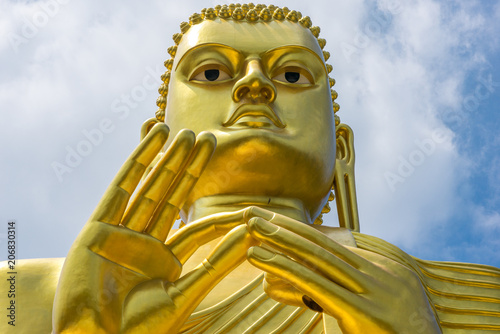 Huge golden Buddha statue on top of the Buddhist Museum of the Golden Temple Dambulla