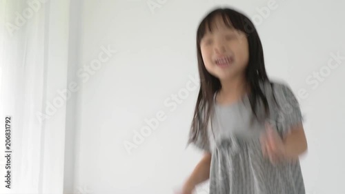 Little asian girl having fun dancing in a room at home 