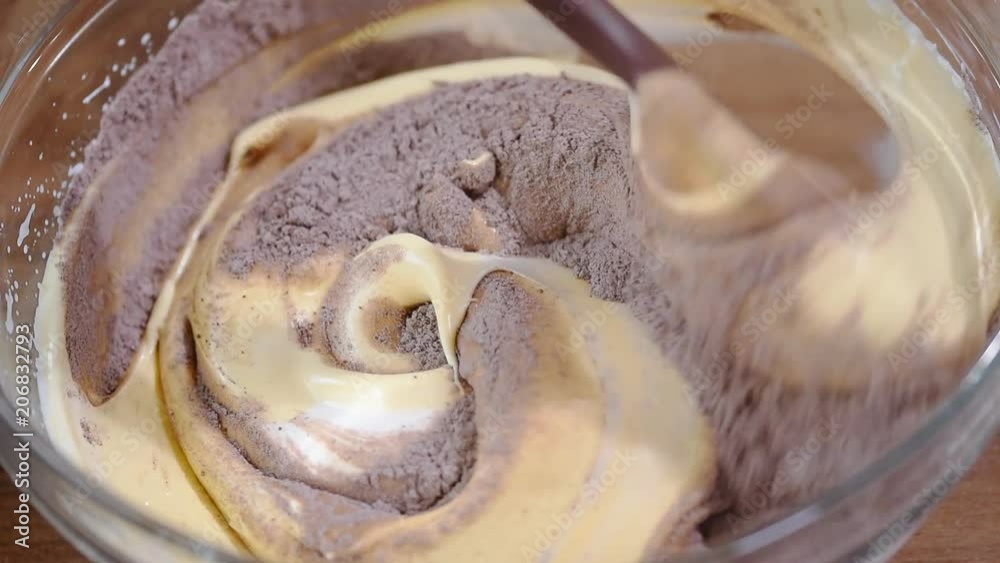 Bowl of chocolate batter being stirred around. The process of making chocolate batter. Bowl of chocolate batter being stirred around. The process of making chocolate batter.