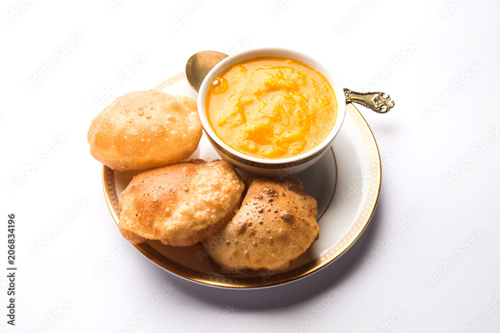 Aam Ras Puri OR Alphonso Mango pulp with fried Poori, selective focus Aam Ras Puri OR Alphonso Mango pulp with fried Poori, selective focus