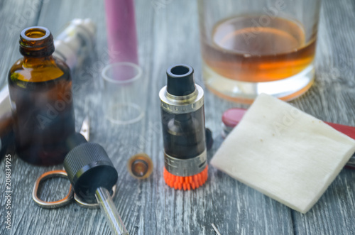 Still life with e-cig and jiuce on the wooden background photo