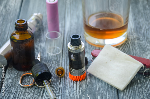 Still life with e-cig and jiuce on the wooden background photo