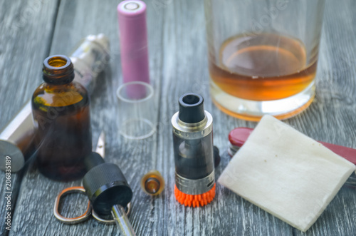 Still life with e-cig and jiuce on the wooden background photo