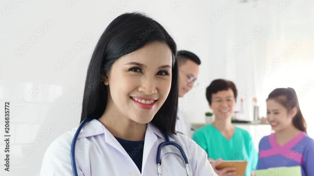 Beautiful asian doctor standing and smiling in front of medical team meeting on background
Beautiful asian doctor standing and smiling in front of medical team meeting on background