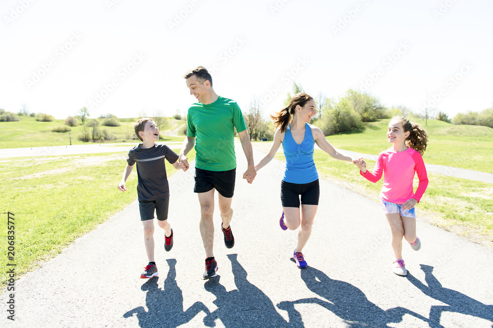 Obraz premium Parents with children sport running together outside