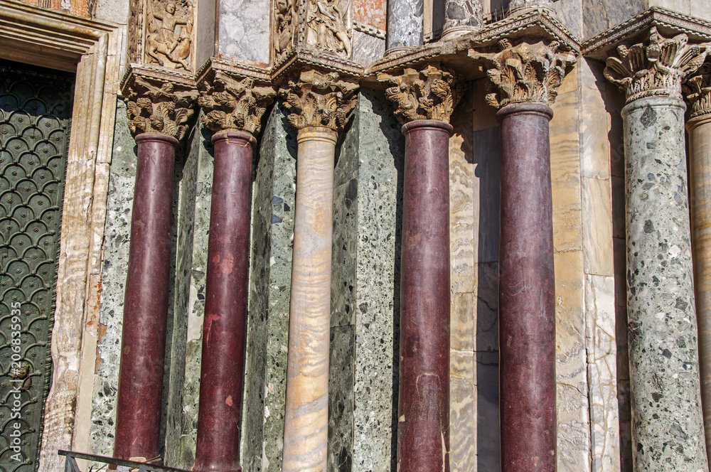 Close-up of columns and capitals made of various types of marble on the San Marco Basilica facade. At the city of Venice, the historic and amazing marine city. Located in Veneto region, northern Italy